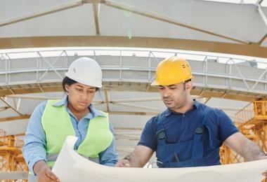Site workers in safety helmets, the workforce protected by workmen's compensation insurance in the UAE