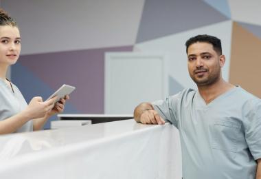 Two clinic staff at a reception desk, the kind of everyday care a Dubai basic medical insurance plan is built around